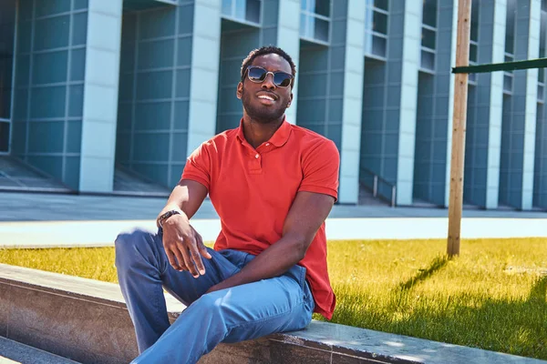 Guapo afro estudiante está sentado cerca de su trabajo —  Fotos de Stock