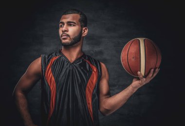 Siyah bir adam bir sepet topu tutar.