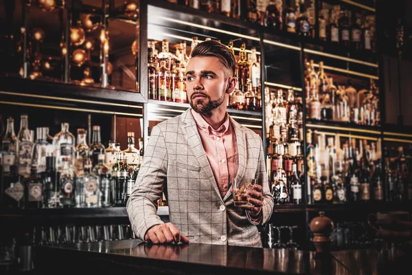 Elegante hombre arreglado está bebiendo alcohol en el bar — Foto de Stock