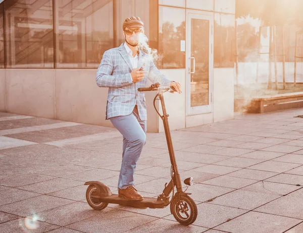 Elegante uomo con elettro scooter fuma vaporizzatore — Foto Stock