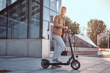 Genç adam onun yontmlı elektro scooter sürüyor