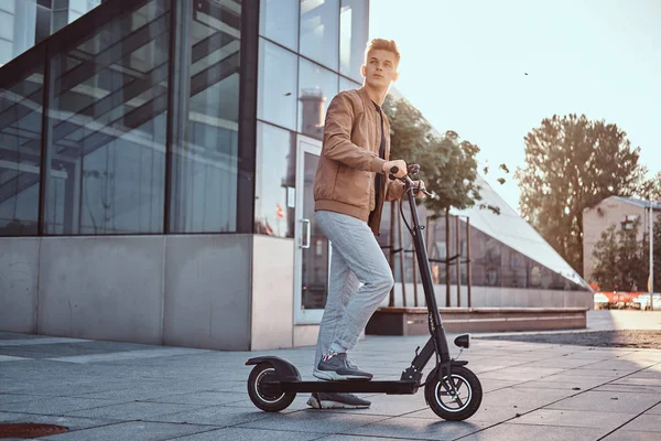 Genç adam onun yontmlı elektro scooter sürüyor