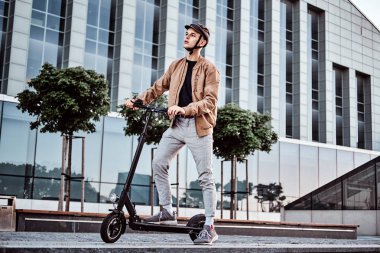 Genç adam onun yontmlı elektro scooter sürüyor