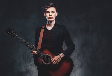 Yakışıklı adam fotoğraf stüdyosunda gitar çalıyor