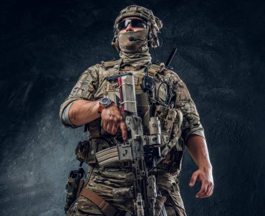 Askeri muhafız makineli tüfeğini tutuyor.