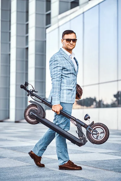 Homem elegante está segurando eletro scooter — Fotografia de Stock