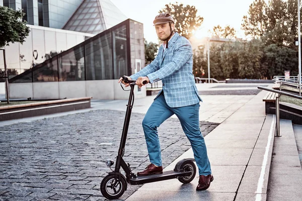 Красивий чоловік їде на скутері біля будівлі офісів — стокове фото