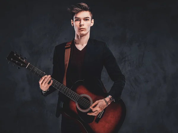 Handsome guy is playing guitar at photo studio — Stock Photo, Image