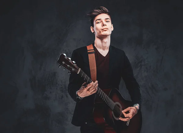 Chico guapo está tocando la guitarra en el estudio fotográfico — Foto de Stock