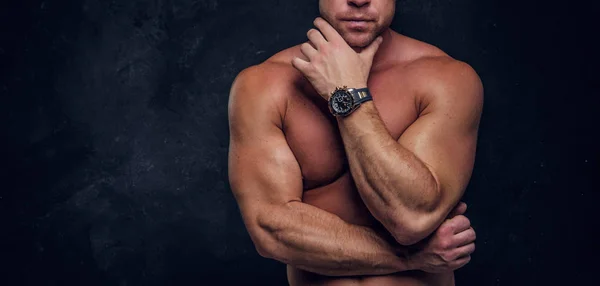 Homem com belo corpo muscular está posando sobre fundo escuro — Fotografia de Stock