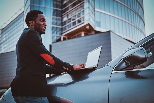 Afro american man is working on his laptop outside — Stock Photo, Image