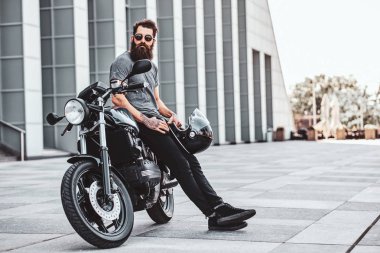 Sakallı bisikletçinin motosikletiyle ürperen portresi