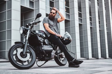 Sakallı bisikletçinin motosikletiyle ürperen portresi