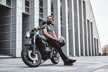 Sakallı bisikletçinin motosikletiyle ürperen portresi