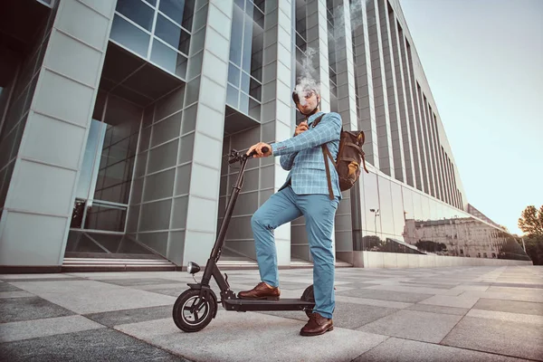 Eleganter Mann mit Elektroroller raucht Dampf — Stockfoto