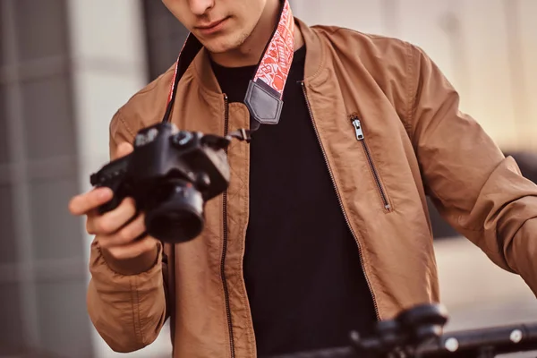 Mann mit Roller und Proto-Kamera schaut Fotos — Stockfoto