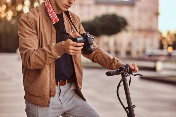 Homem com scooter e câmera proto está assistindo fotos — Fotografia de Stock