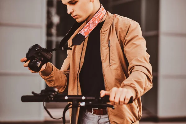 Man with scooter and proto camera is watching photos — Stock Photo, Image