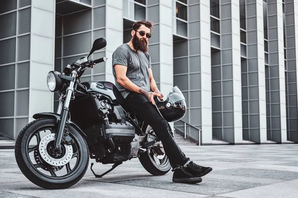 Retrato de motociclista barbudo refrigeração com sua moto — Fotografia de Stock