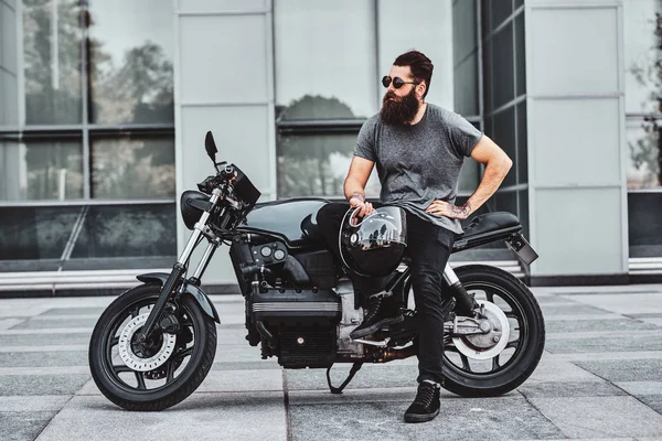 Retrato de motociclista barbudo refrigeração com sua moto — Fotografia de Stock