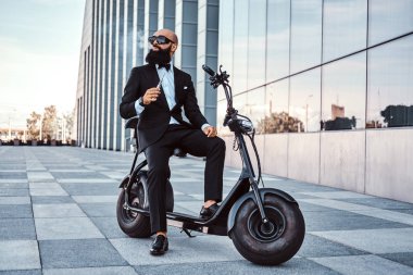 Zarif işadamı elektro bisiklet üzerinde otururken sigara içiyor