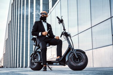 Zarif işadamı elektro bisiklet üzerinde otururken sigara içiyor