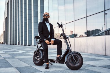 Modern adam yeni elektro scooter'ının üzerinde oturuyor.