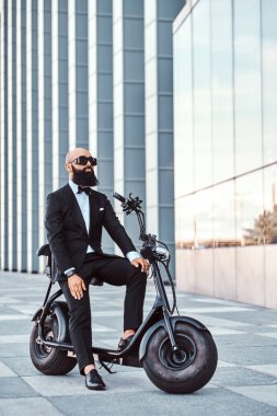 Modern adam yeni elektro scooter'ının üzerinde oturuyor.