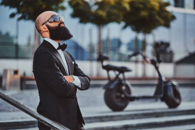 Adam elektro bisikletinin yanında duruyor.