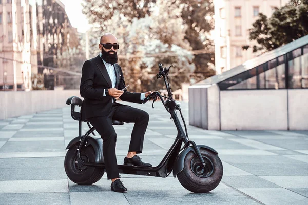 Modern adam yeni elektro scooter'ının üzerinde oturuyor.