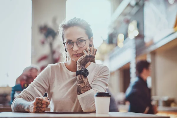 Portret van mooie tattoed meisje met schets pad — Stockfoto