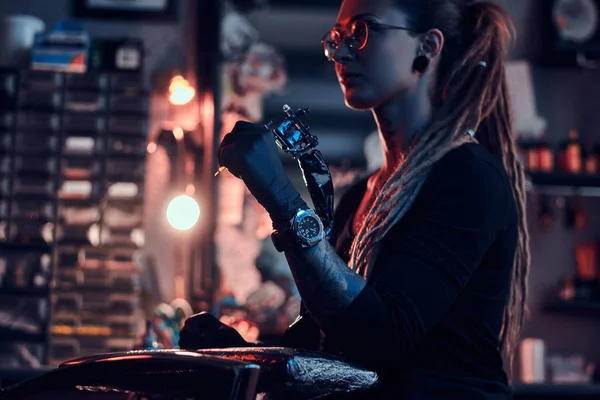 Ritratto di giovane donna attraente con macchina del tatuaggio in mano — Foto Stock