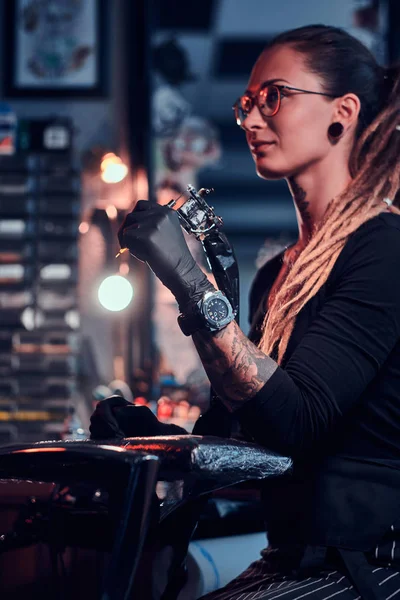 手にタトゥーマシンを持つ魅力的な若い女性の肖像画 — ストック写真