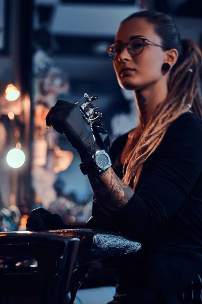 Portrait de jeune femme attrayante avec machine à tatouer dans les mains — Photo