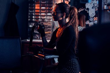 Genç dövme sanatçısı kendi dövme stüdyosunda oturuyor