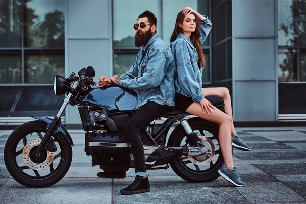 Retrato de pareja en chaquetas de mezclilla con moto —  Fotos de Stock