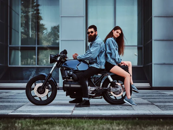 Retrato de pareja en chaquetas de mezclilla con moto —  Fotos de Stock