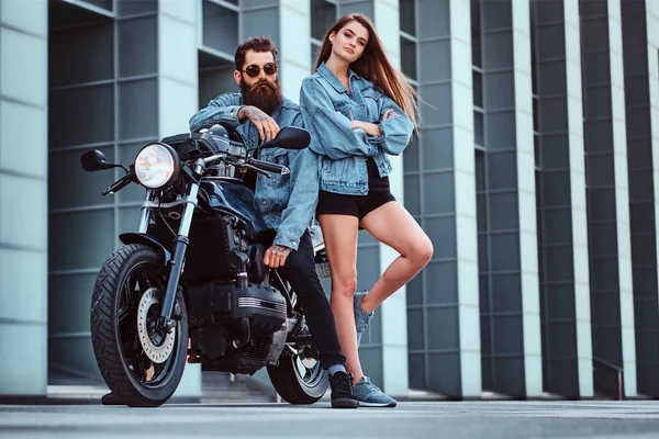 Retrato de pareja en chaquetas de mezclilla con moto — Foto de Stock