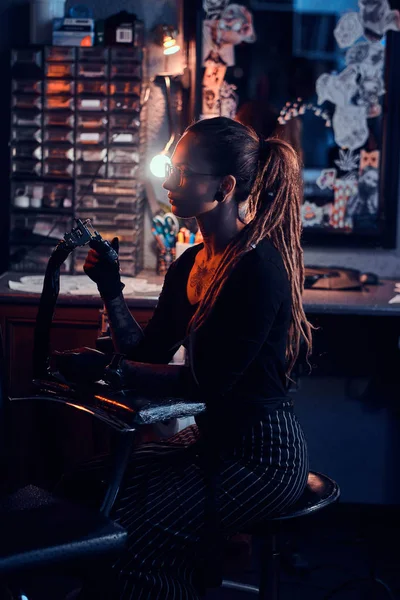 Giovane tatuatrice è seduta al suo studio di tatuaggio — Foto Stock