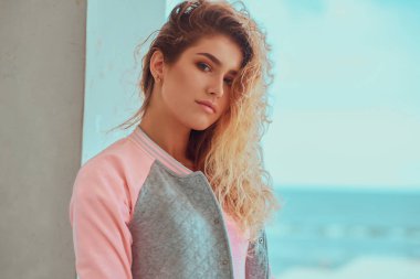 Sarışın kız deniz kenarında fotoğrafçı için poz.