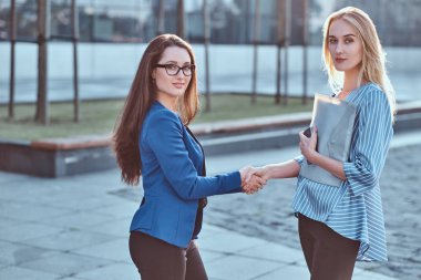 Ofis dışında iki genç kooperatif işçilerin el sıkışma