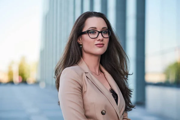 Young elegant woman is posing for photographer on the street — Stock Photo, Image