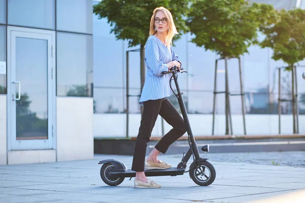 Mujer joven está disfrutando de montar en su nuevo scooter — Foto de Stock