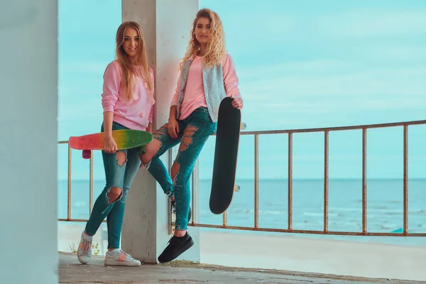 Две привлекательные девушки позируют со скейтбордами — стоковое фото