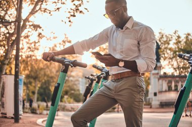 Adam cep telefonunu kullanarak elektro scooter için ödüyor