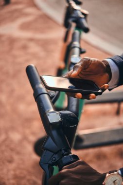 Adam cep telefonunu kullanarak elektro scooter için ödüyor