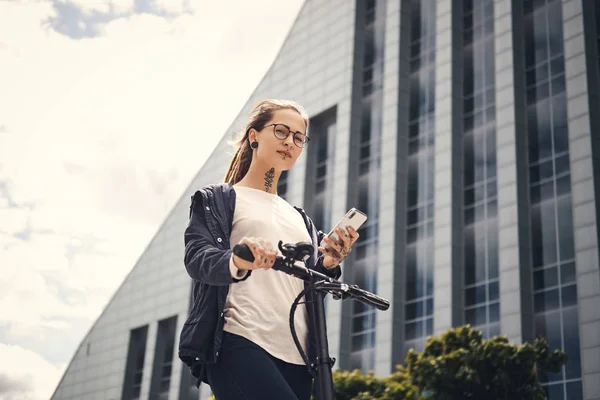 Portrait of young styilish woman with electro scooter