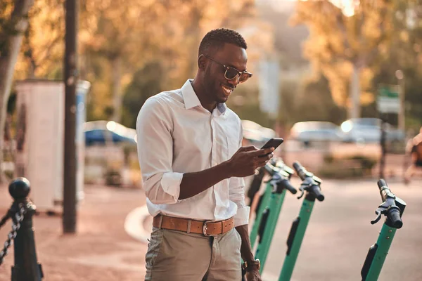 Adam cep telefonunu kullanarak elektro scooter için ödüyor — Stok fotoğraf