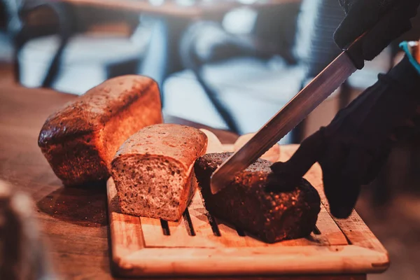 Mutfak işçisi öğle yemeği için ekmek dilimleme