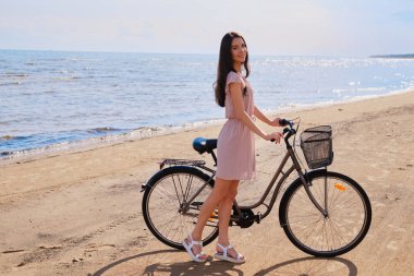 Deniz kenarında bisikletiyle güzel esmer portresi